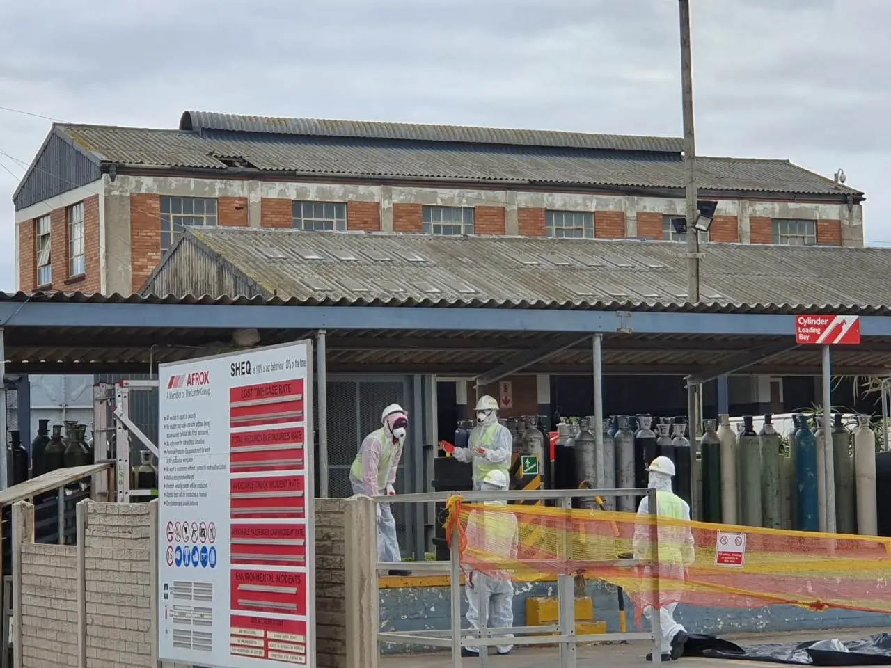 Sicon Group team in full protective equipment carrying out asbestos removal at an industrial site with an old asbestos-cement roof