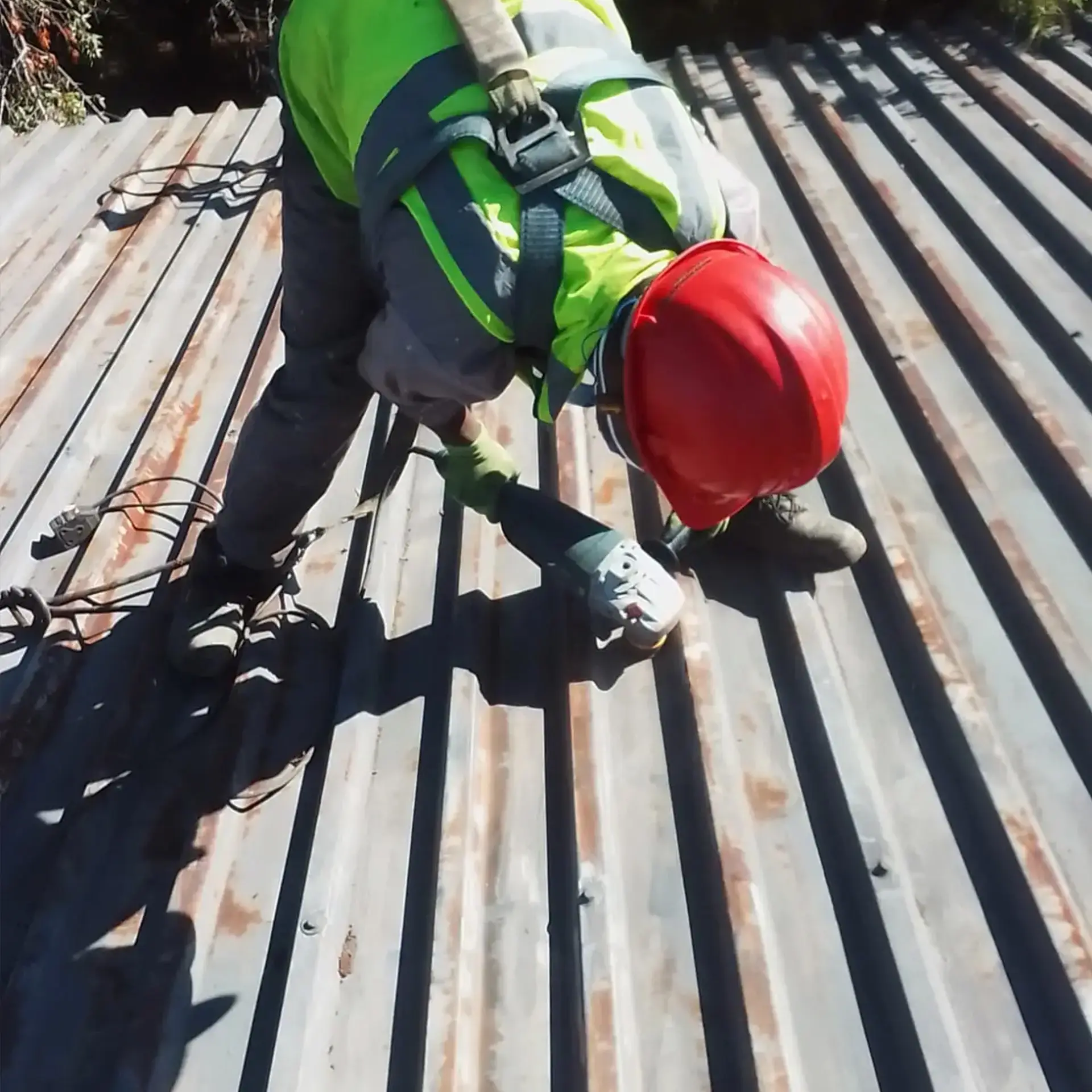 Maintenance team refreshing protective coating on a white industrial roof to prevent leaks