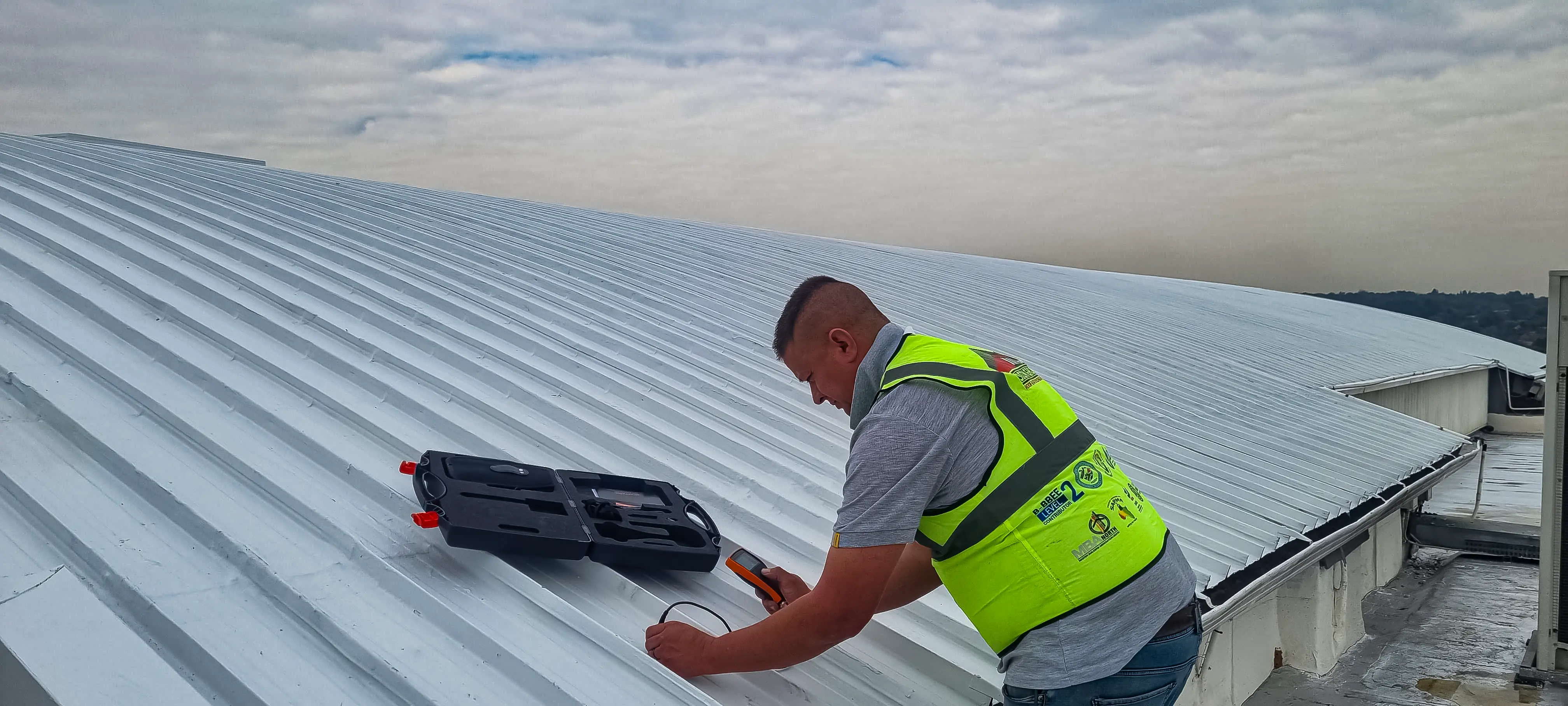 Sicon Group technician measuring coating thickness on an industrial metal roof during a quality control inspection
